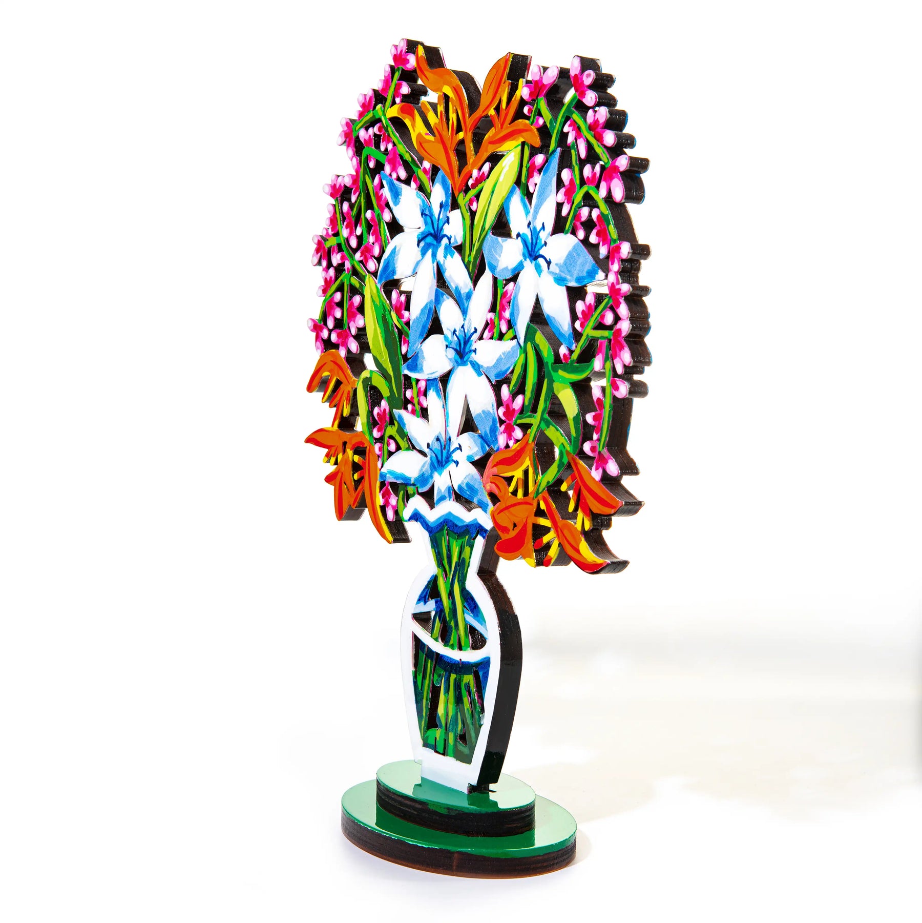 A a sculpture of a vibrant bouquet of blue and white flowers with orange and pink accents, displayed in a stylized, modern vase is seen at an angle against a white backdrop.