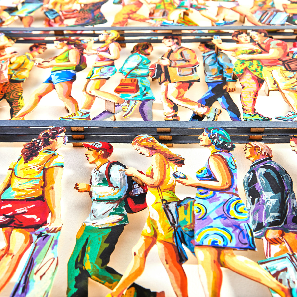 A close-up view of David Gerstein's '5th Avenue' papercut sculpture, highlighting the layers and intricate details. The bright colors and sharp contours stand out against the white backdrop, emphasizing the texture and depth of the artwork.