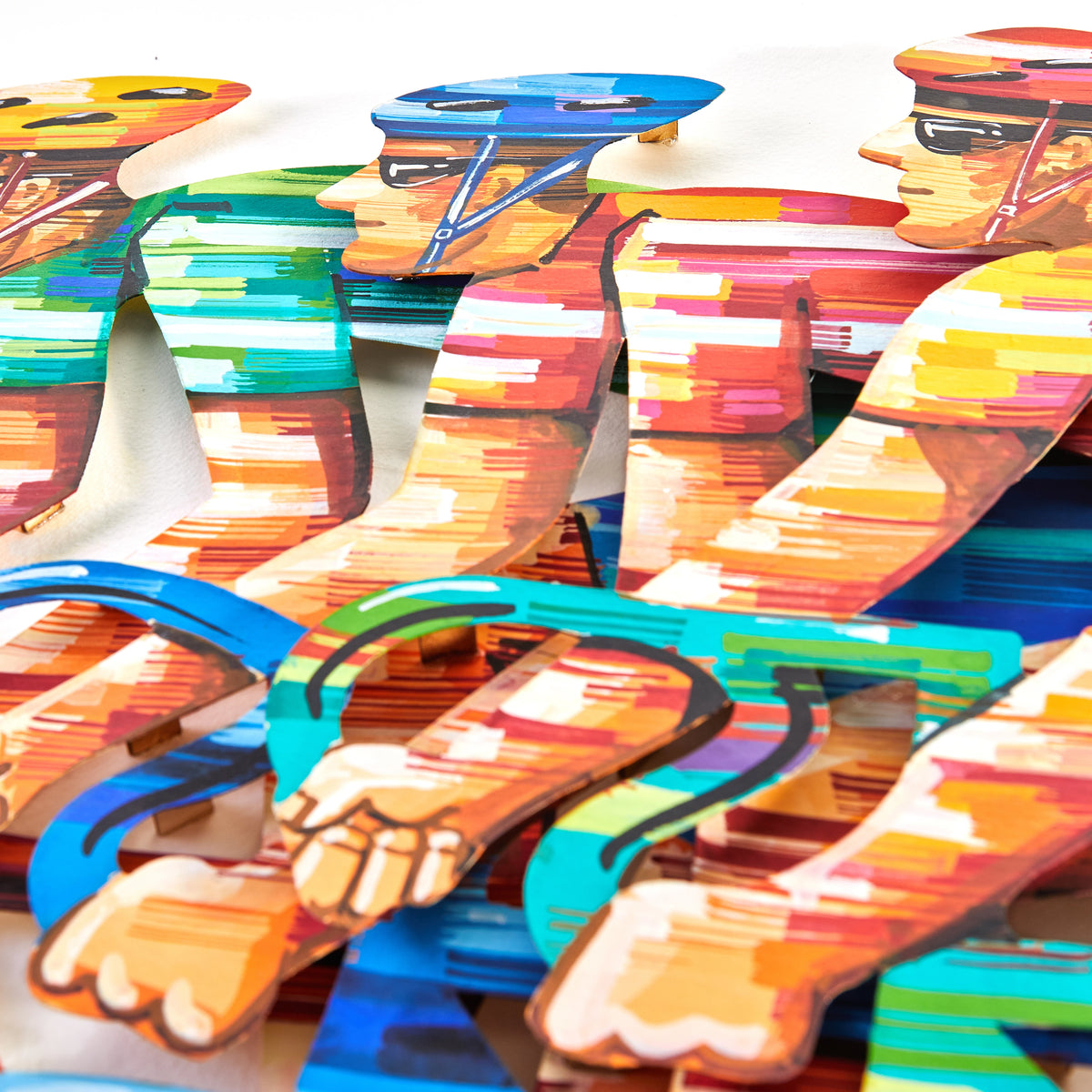 A close-up image of David Gerstein's papercut artwork depicting three people racing bicycles, each figure intricately cut and set against a clean white background, highlighting the delicate details and motion of the scene.