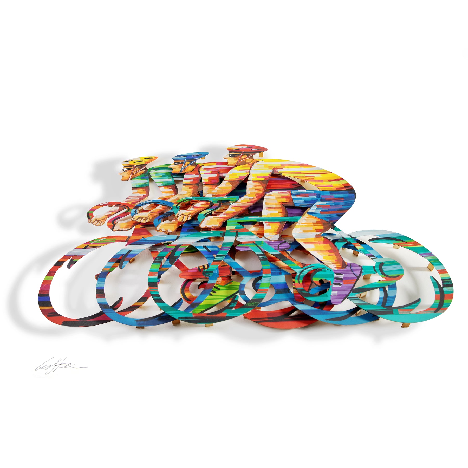 Papercut artwork depicting three people racing bicycles, each figure intricately cut and set against a clean white background, highlighting the delicate details and motion of the scene. The image is taken from an angle so that you can see the layers.