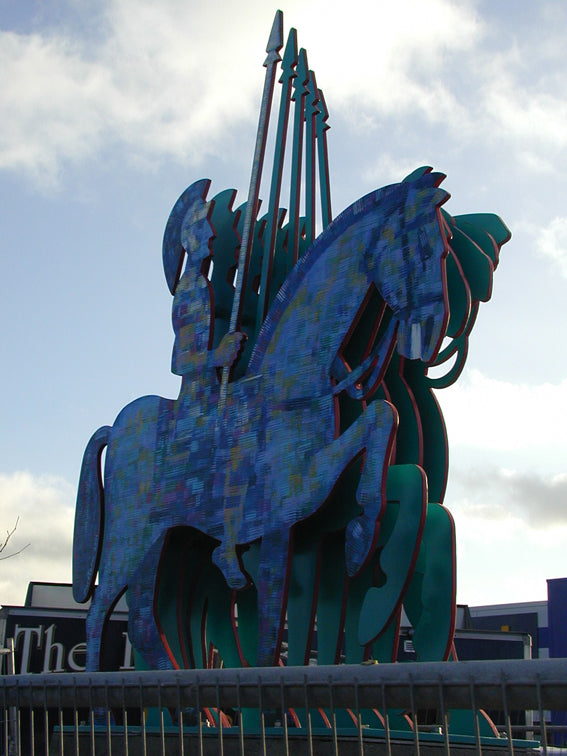 Colorful sculpture of a horse with a spear against a cloudy sky