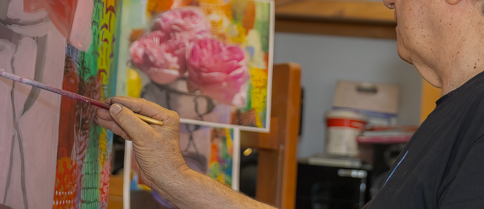 Close-up of David Gerstein painting a colorful metal sculpture, capturing his detailed artistic process.